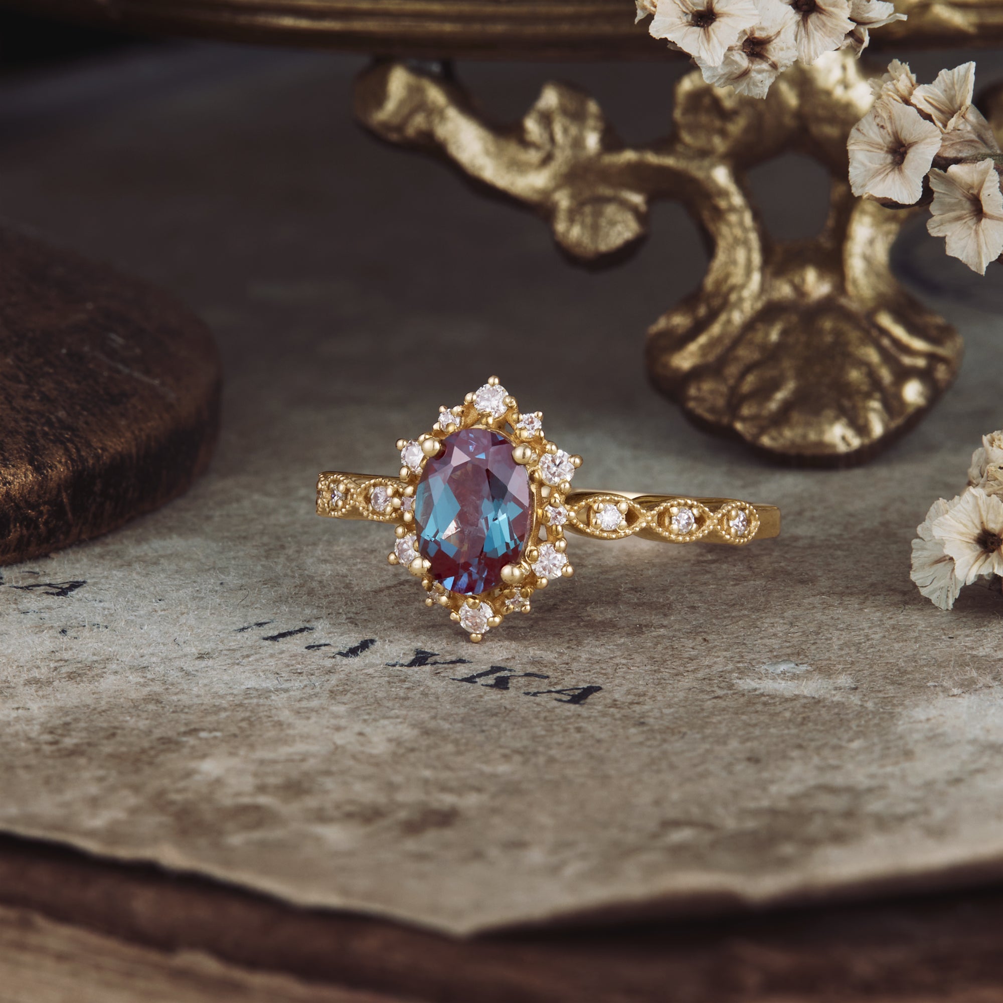 Oval Alexandrite cluster ring with moissanite accents and ornate gold band.